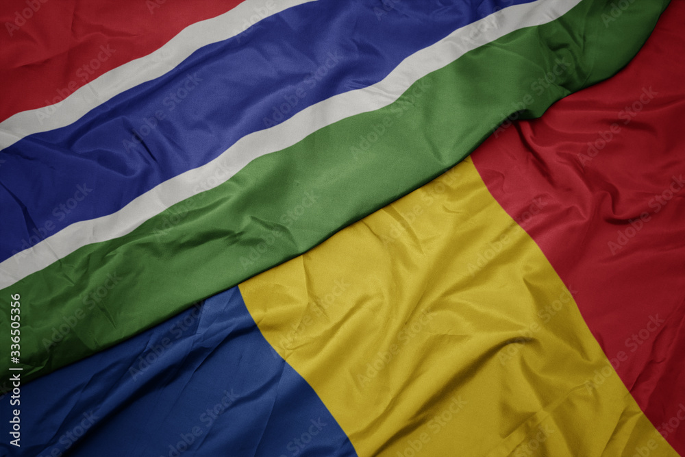 waving colorful flag of romania and national flag of gambia.