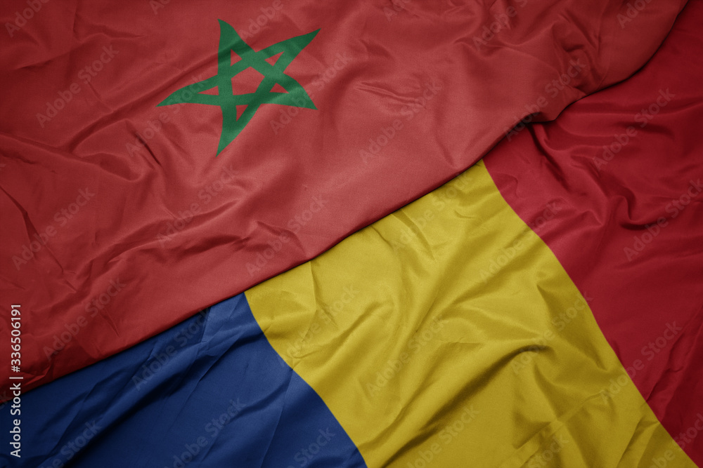 waving colorful flag of romania and national flag of morocco.