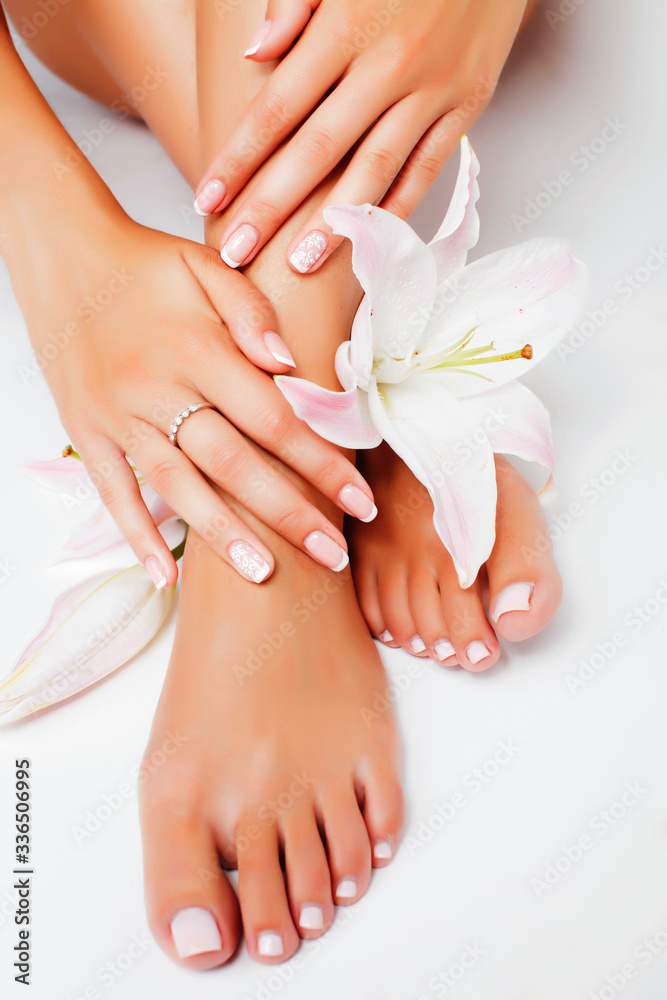 Fototapeta premium manicure pedicure with flower lily closeup isolated on white background perfect shape hands spa salon