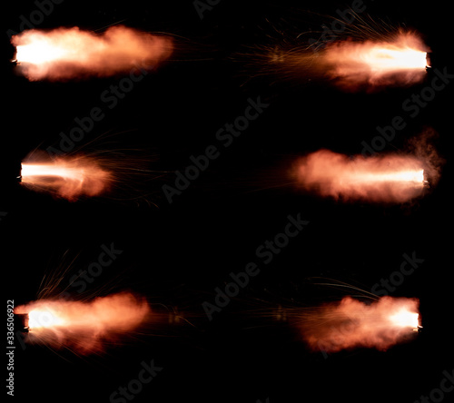A shot from a firearm on a black background  a fiery exhaust with flying sparks  flames bursting out of the pipe