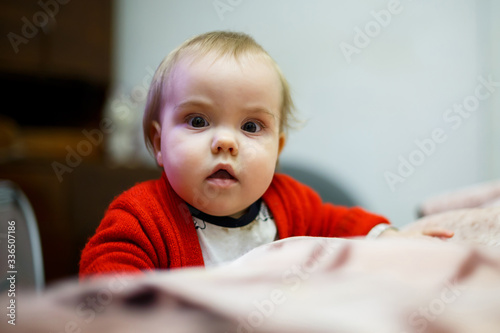 little child girl in a red sweater, her face is dirty with food, beautiful bokeh