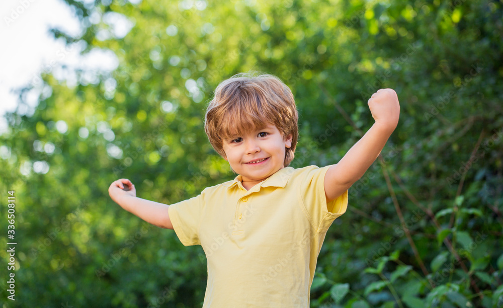 Child outdoors in nature. Happy child. Funny baby boy isolated on a background of green trees. Smiling child boy. Cheerful cheerful kid. Happy children kid boy with hands up Child outdoors in nature. Happy child. Funny baby boy isolated on a background of green trees. Smiling child boy. Cheerful cheerful kid. Happy children kid boy with hands up