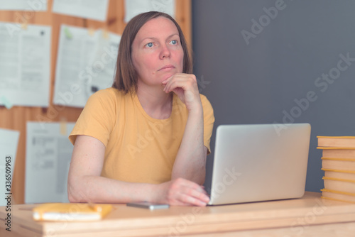 Obraz na plátně Thoughtful female freelance translator working in home office