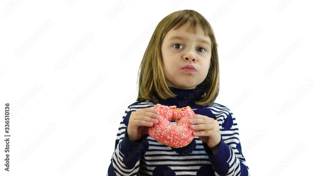 Little girl is eating a donut on a white background. Little girl is eating a donut on a white background.
