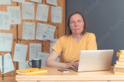 Thoughtful female freelance translator working in home office photo