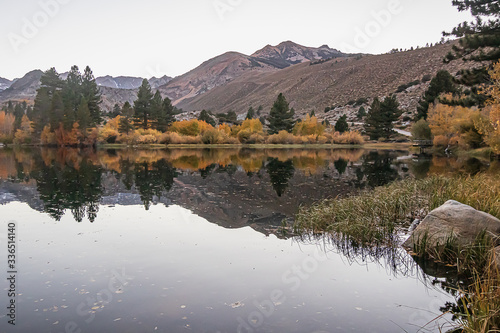 Fototapeta Naklejka Na Ścianę i Meble -  reflecctive mountain lake with pines aspens grass and mountain
