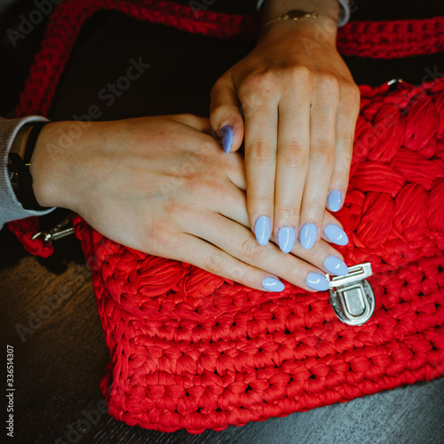 Kobiece dłonie z niebieskimi paznokciami 