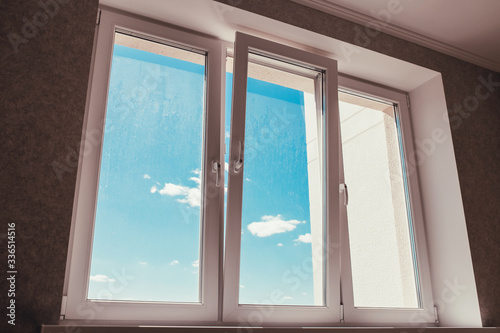 New apartment in a new building - dirty dusty windows after repair - view of the blue sky - housewarming