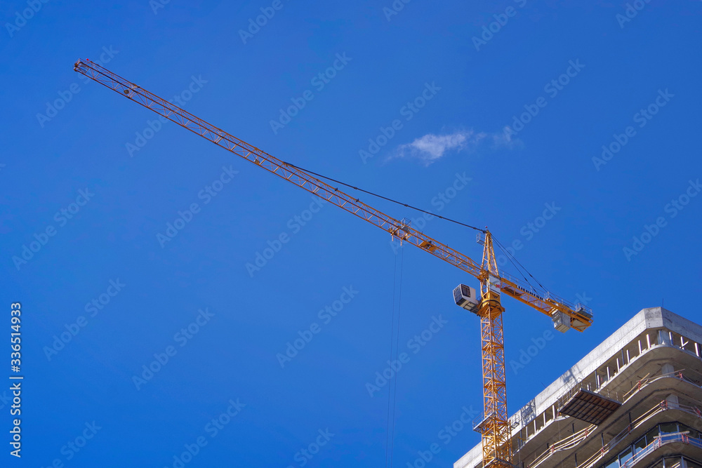 Crane on a background of blue sky. Modern construction.