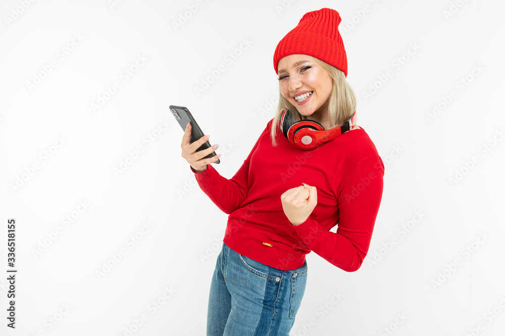 energetic charismatic blonde girl with a smartphone and headphones dancing on a white background energetic charismatic blonde girl with a smartphone and headphones dancing on a white background