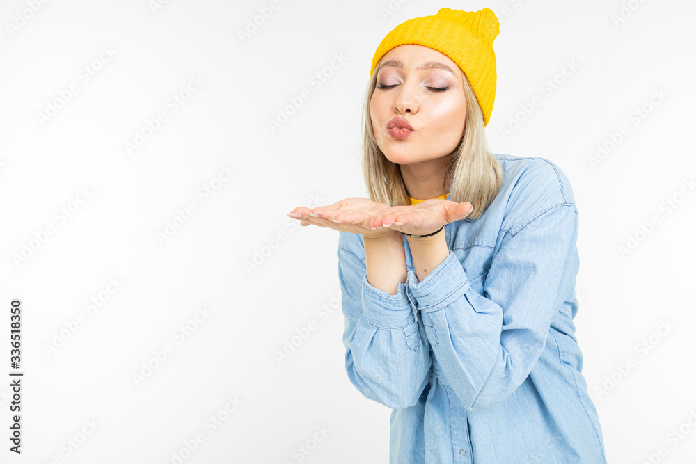 happy blonde charming young woman in casual look with jeans shirt sends kisses on a white background happy blonde charming young woman in casual look with jeans shirt sends kisses on a white background