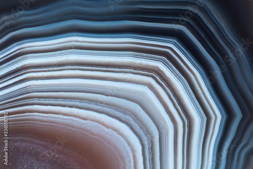 Close-up texture of red-blue agate with contrast white stripes