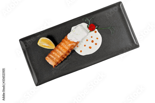 fish baked salmon with sauce on a dark dish