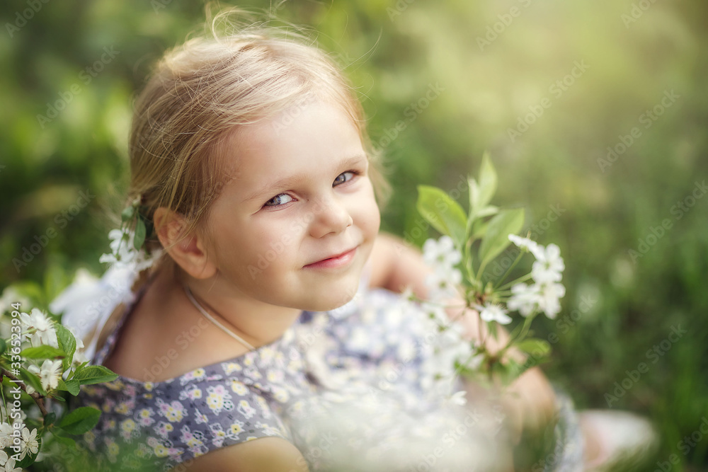 baby girl walks in spring in a blooming garden, happy childhood, cherry blossoms, month of may baby girl walks in spring in a blooming garden, happy childhood, cherry blossoms, month of may