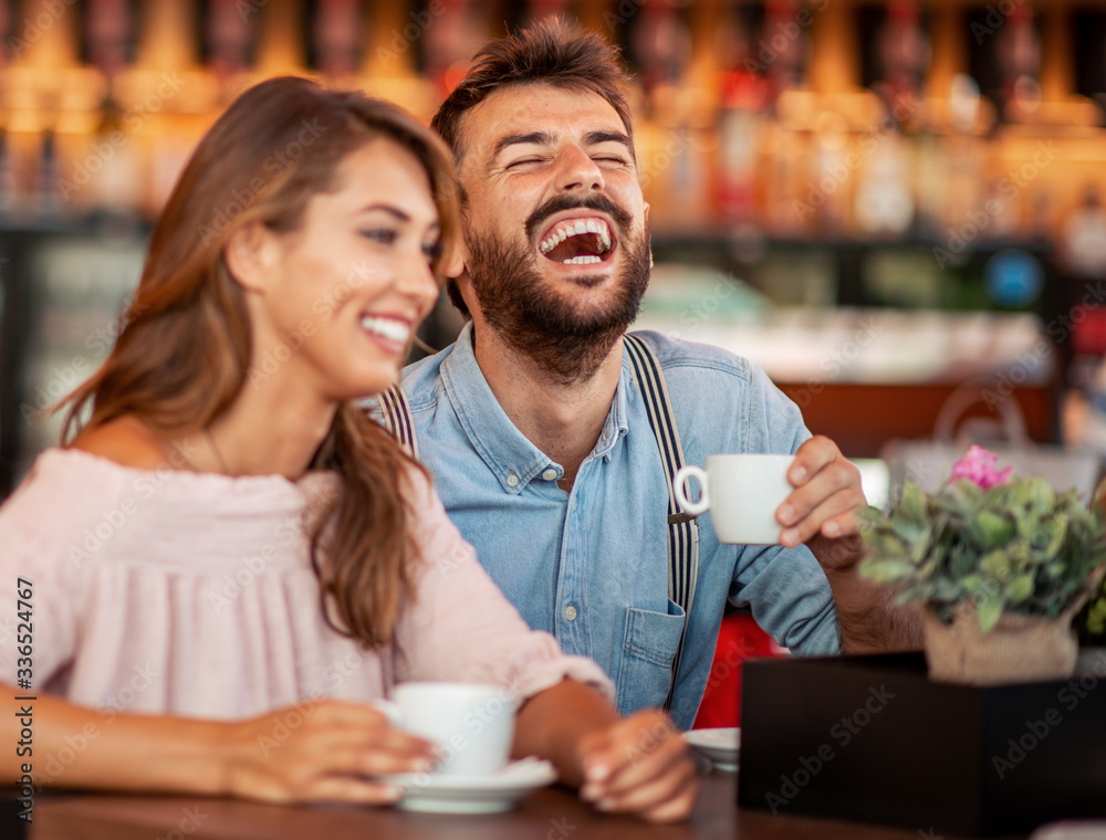 Fototapeta premium Young couple sitting at cafe table and having coffee together.