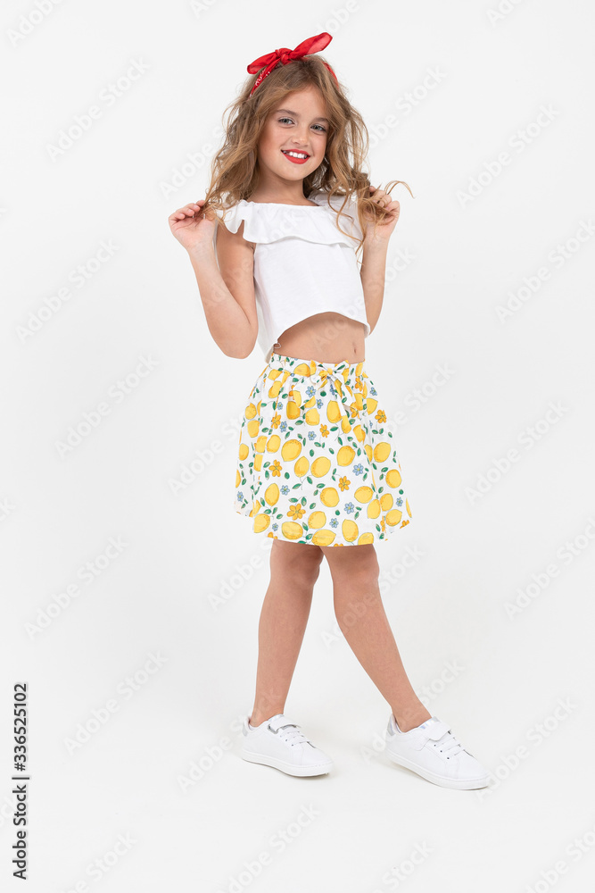 Naklejka premium attractive teenager girl in a white T-shirt and skirt flirts in full growth on a white background with copy space