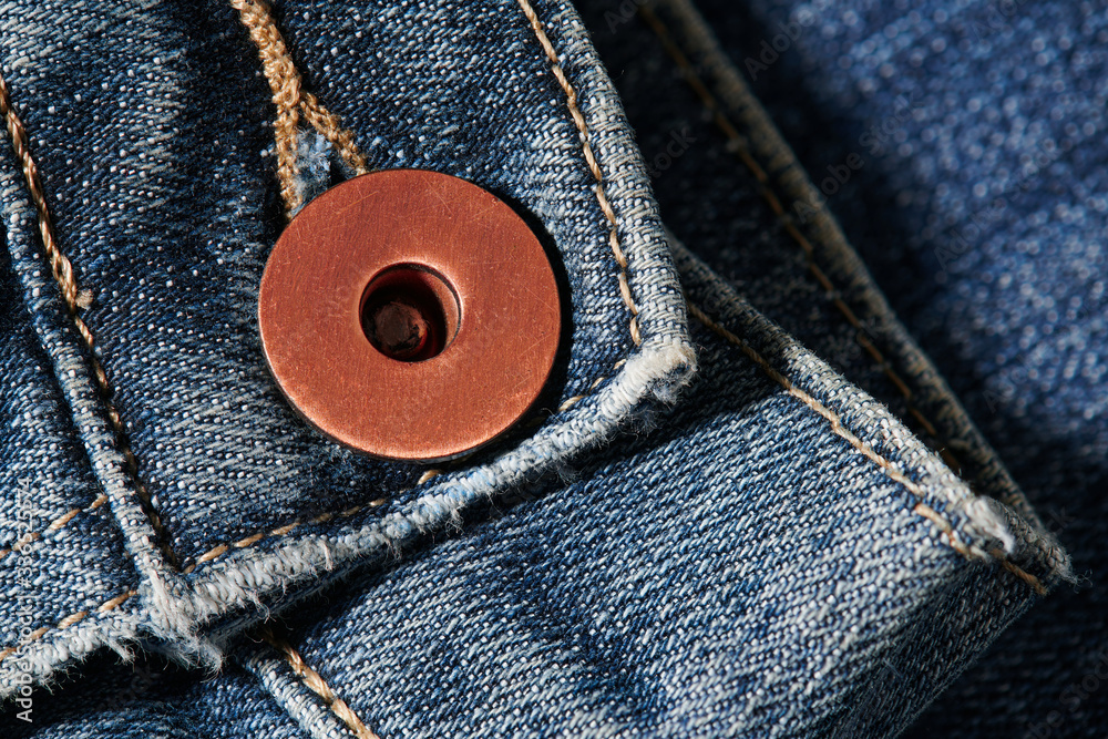 sleeve and a brass button with jeans natural clean background macro photo, dark blue pattern texture, design for background with copy space for text sleeve and a brass button with jeans natural clean background macro photo, dark blue pattern texture, design for background with copy space for text