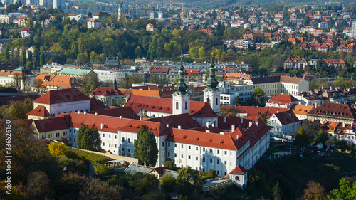 Beautiful view of Prague from the highest part of the city. Sunny weather, bright sky and river. Tile roofs glisten in the sun.