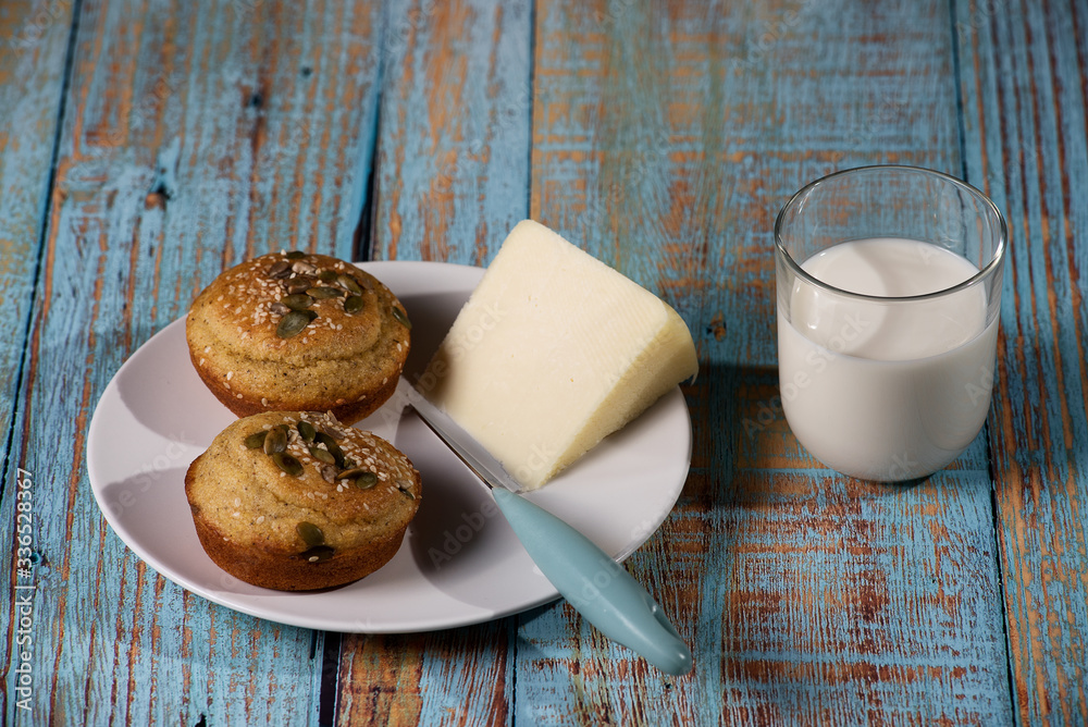 Corn bread made in the form of muffins ( proja ) with sesame and pumpkin seeds with cheese and glass of yogurt. Balkan cuisine. Blue rustic wooden background Corn bread made in the form of muffins ( proja ) with sesame and pumpkin seeds with cheese and glass of yogurt. Balkan cuisine. Blue rustic wooden background