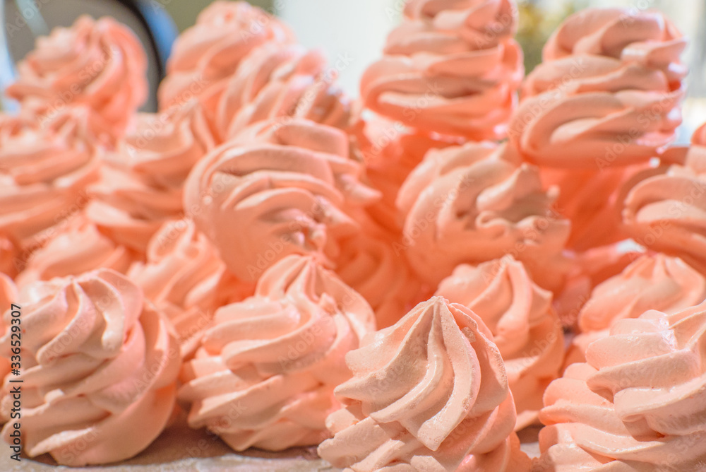 Delicious pink freshly made meringues laid out on a concrete background. Sweet food. Delicious pink freshly made meringues laid out on a concrete background. Sweet food.