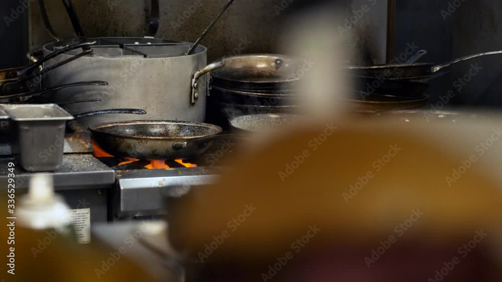 Large amount of kitchenware and fire. Stove with fire and food being cooked. Large amount of kitchenware and fire. Stove with fire and food being cooked.