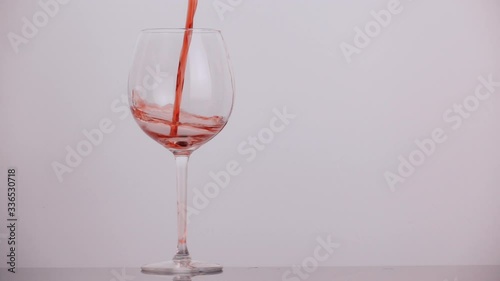 pours wine into a glass in slow motion