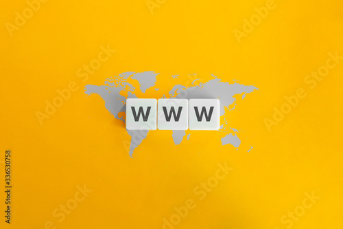 WWW (World Wide Web) on block letters. Grey world map on bright orange background.