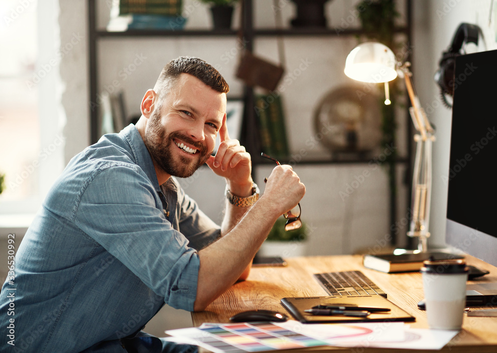 © JenkoAtaman - Young man working at computer at workplace.