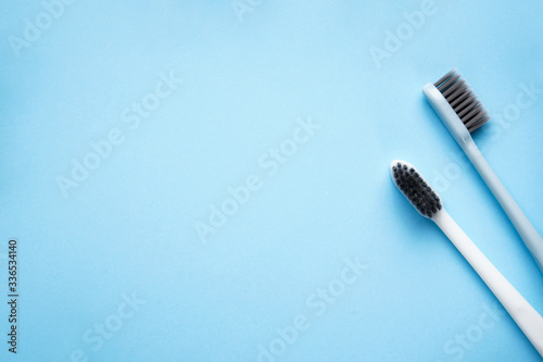 Two toothbrushes on a blue background with space for text, flat lay. © VI Studio