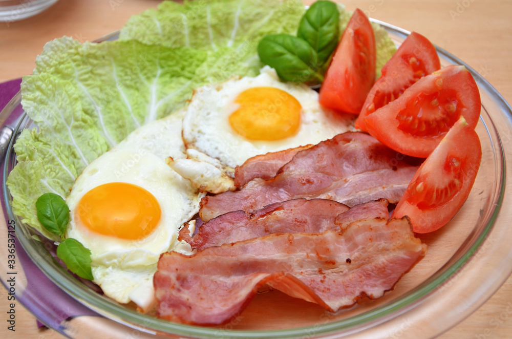 nutritious  breakfast bacon and fried eggs with vegetables close-up 