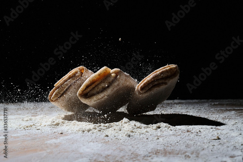 pancakes made of dough in flour on a dark background close up