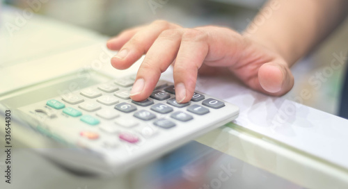 Female finger pressing the calculator to calculate and analyze income and expenses the growth of business