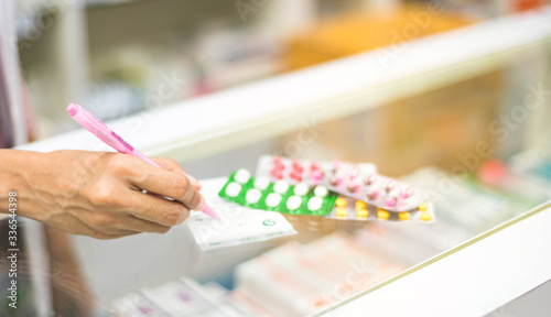 Female pharmacist preparing medicine capsule pack  pharmacy to sell to patient for protect coronavirus,