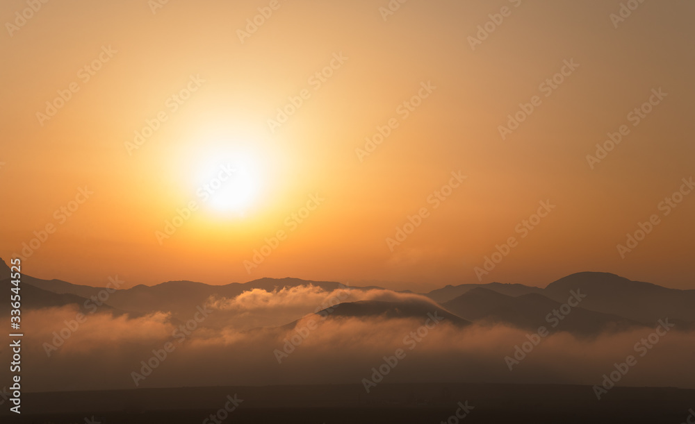 Landscape of sunset over the mountains and fog