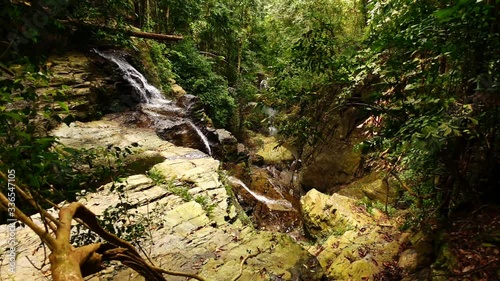 Top view of the Khung Shi waterfall in Thailand jungle. Slow motion shoot of the water cascade falling into the abbyss between cliffs. Theme of the nature and it's beauty that's charming. photo