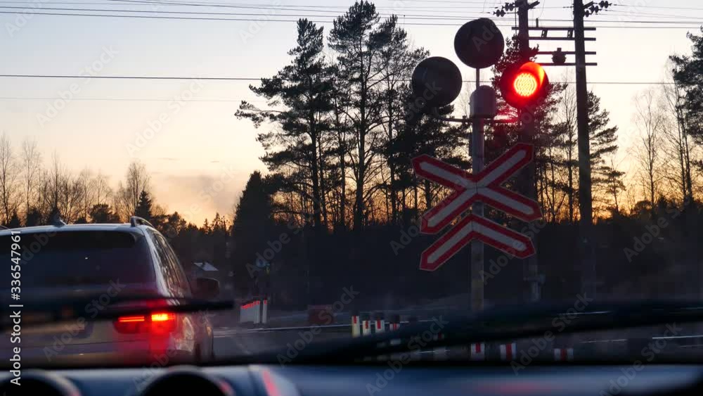 Railroad crossing, flashing red light, car in front. A passing train at a railway crossing.