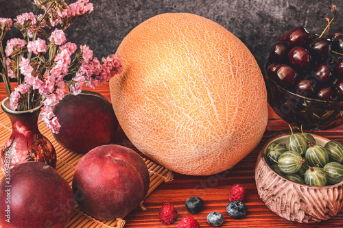 Melon on wooden table with black background