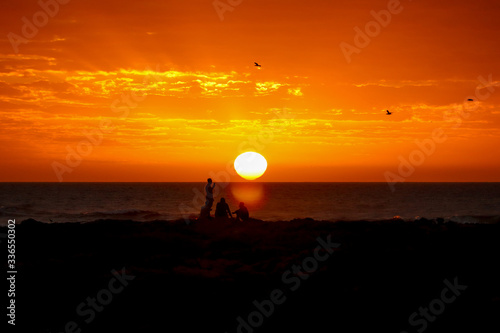 Nascer do sol observado por jovens na Playa El Emir, Punta del Este, Uruguai
