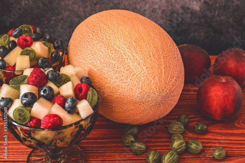 Melon on wooden table with black background