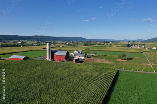 Aerial Beautiful Ohio Amish countryside farm house. Settled late 1700's as pioneer religious settlement. Old Amish Mennonite town. Rural order. Farming landscape. Old Amish Mennonite settlement.