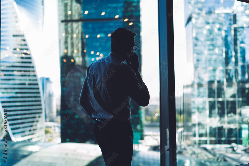 Faceless manager talking to colleague on phone in office Faceless manager talking to colleague on phone in office