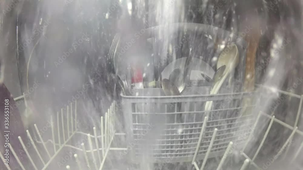 Inside the dishwasher. The process of washing dishes. Water jets spray