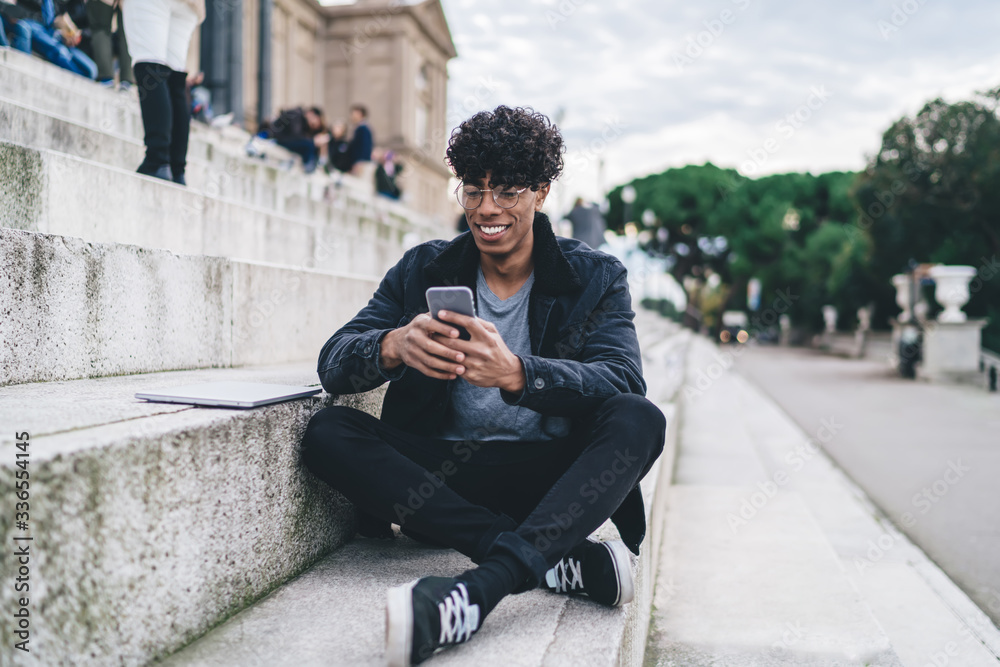 Smiling African American man using smartphone outdoors Smiling African American man using smartphone outdoors