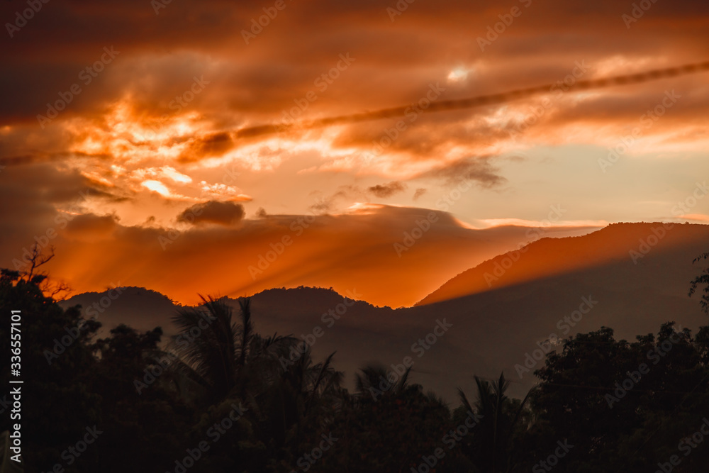 Fiery orange rays of sunset in the mountains