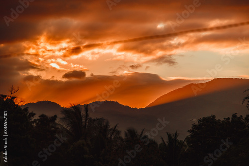 Fiery orange rays of sunset in the mountains