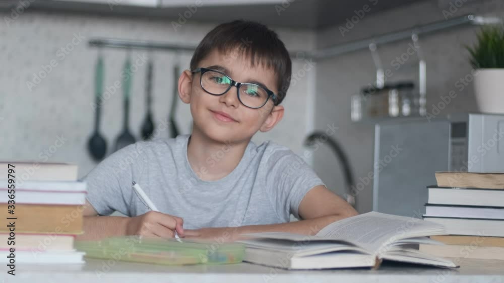 A boy does homework using many textbooks and books. Camera Move Right A boy does homework using many textbooks and books. Camera Move Right