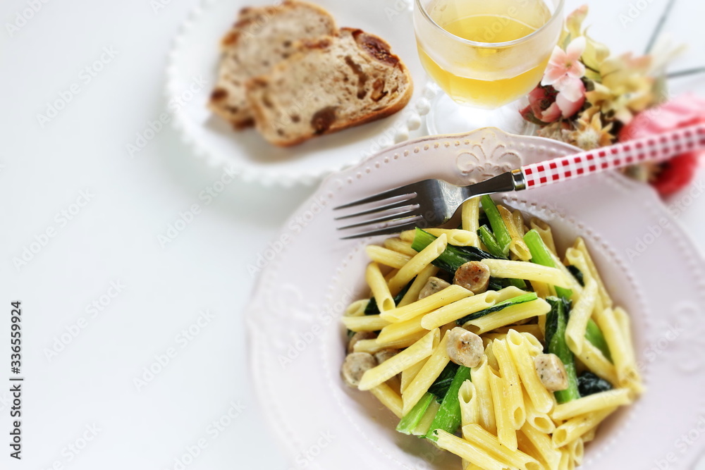 Italian food, penne and sausage with green leaf vegetable

