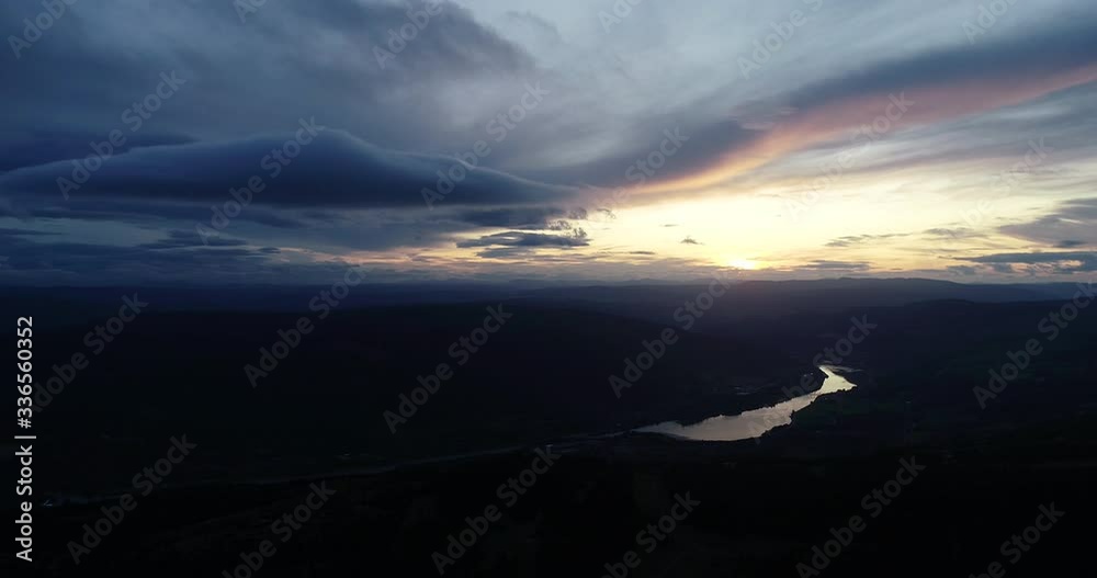 Aerial view of forest in the mountains during peaceful sunset in the valley.