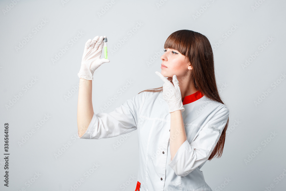 Female researcher or scientist using laboratory equipment for syringe in sterile clothing holding the vaccine Female researcher or scientist using laboratory equipment for syringe in sterile clothing holding the vaccine