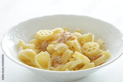 Prepared pasta and tuna salad in white bowl on white background